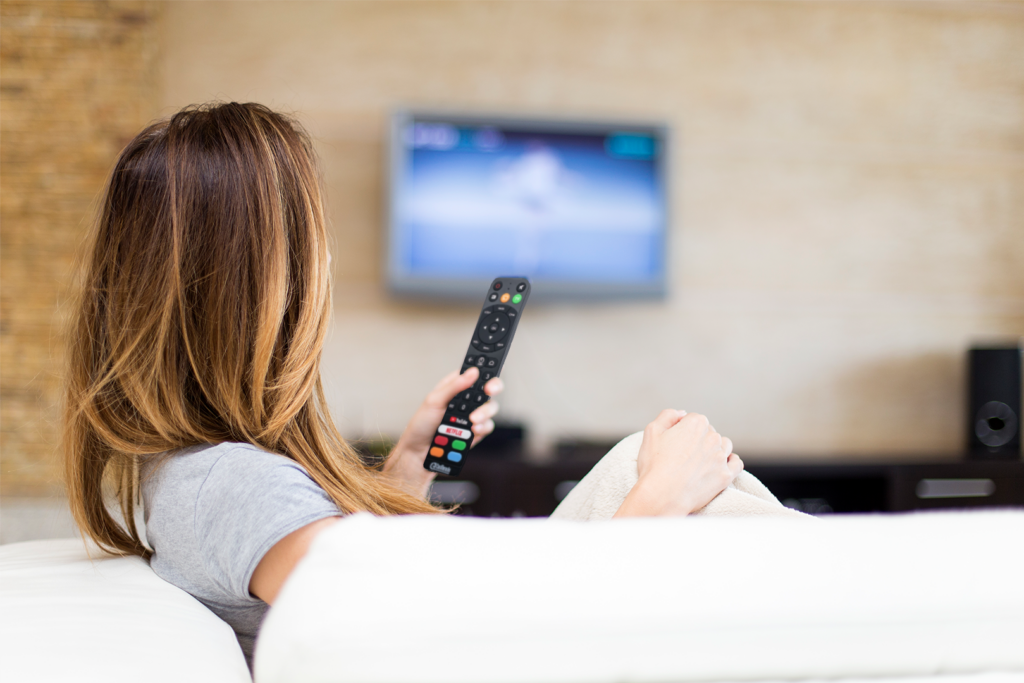 woman holding cast remote watching Chromecast for hospitality